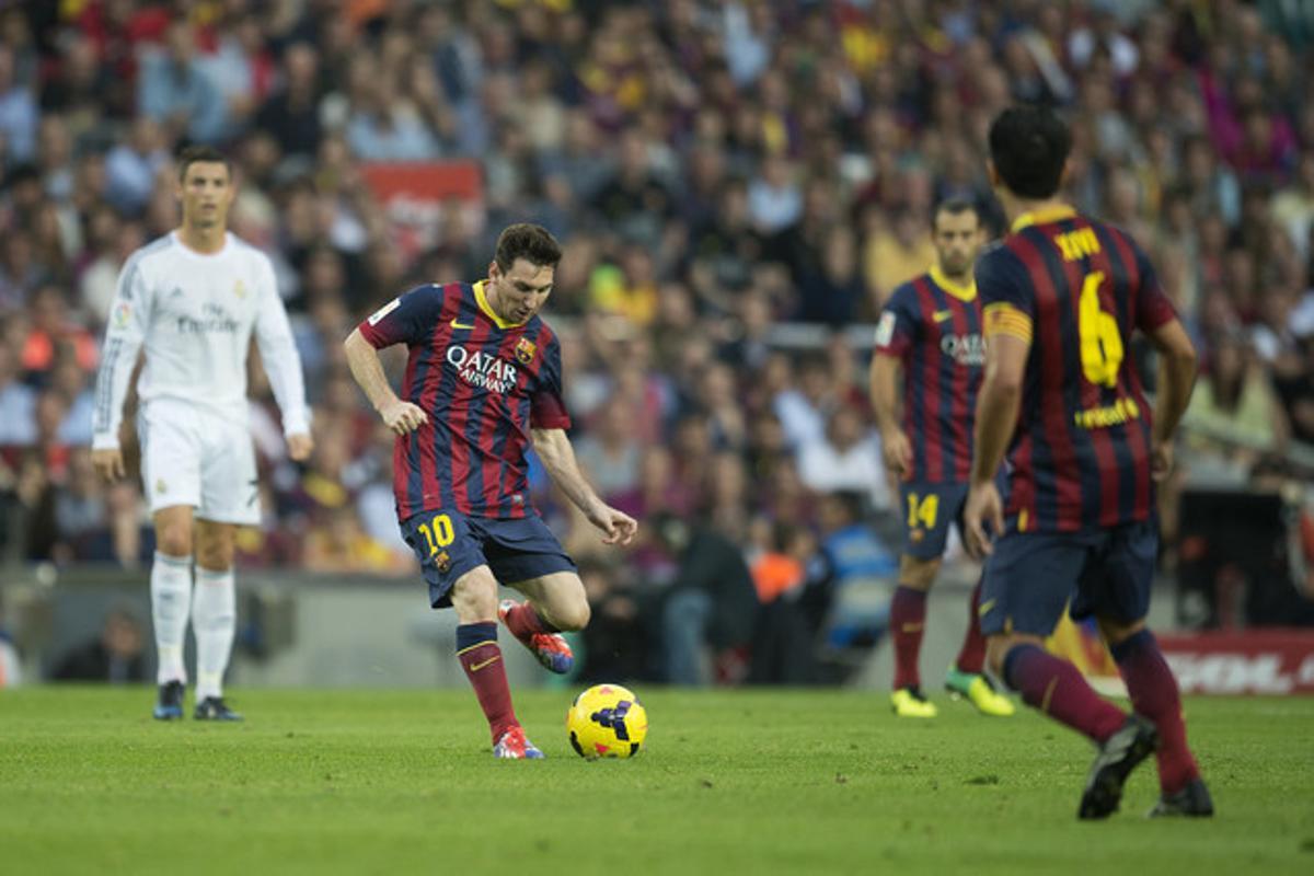Messi envia la pilota a Xavi davant Cristiano Ronaldo i Mascherano, en el passat Barça-Madrid.