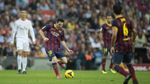 Messi envía el balón a Xavi ante Cristiano Ronaldo y Mascherano, en el pasado Barça-Madrid.