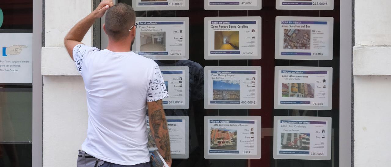 Un hombre observa los anuncios de una inmobiliaria en Las Palmas de Gran Canaria