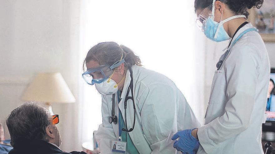 Dos sanitarias atienden a dos personas en su domicilio en Serranillos del Valle (Madrid).