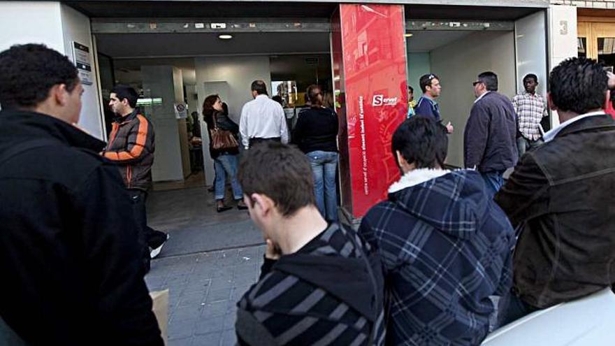 Varias personas hacen cola ante una oficina del Servicio Valenciano de Empleo en Alicante