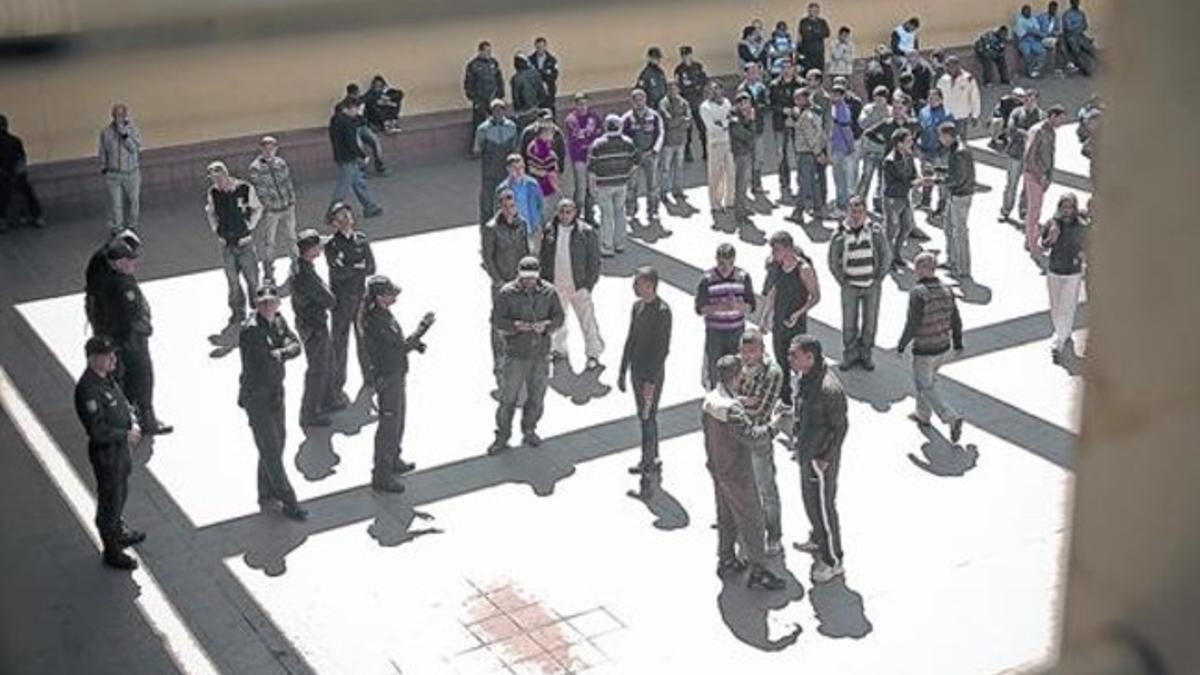 Internos y policías, en el patio del Centro de Internamiento de Extranjeros de la Zona Franca de Barcelona.