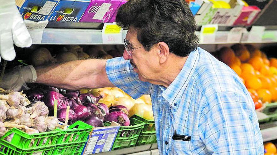 Un hombre hace la compra en un supermercado de las Islas.