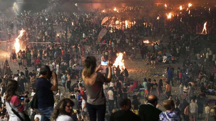 El arenal del Orzán, lleno de personas disfrutando de la noche de San Juan de 2018.