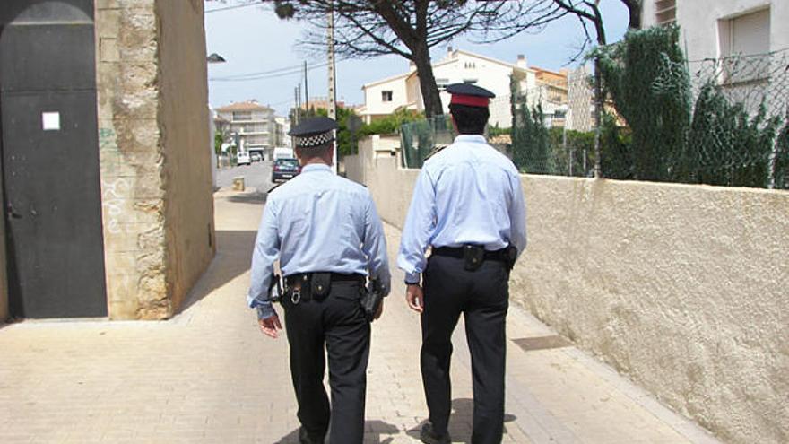 Un policia local i un mosso d&#039;esquadra patrullant en un carrer.