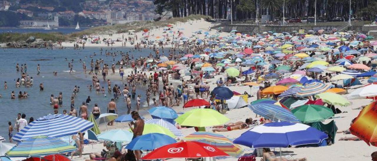 Miles de ciudadanos se refugiaron del calor en el arenal de Samil, que lució abarrotado.