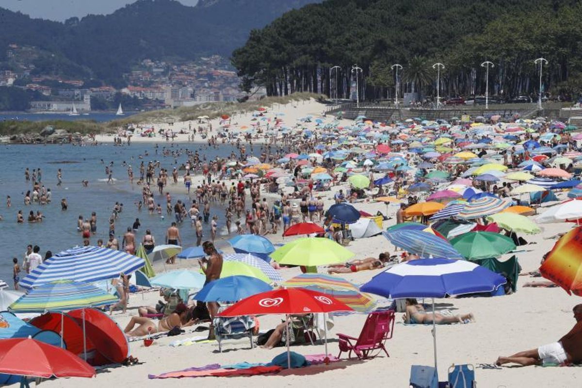 Miles de ciudadanos se refugiaron del calor en el arenal de Samil, que lució abarrotado. | // FOTOS: J. LORES