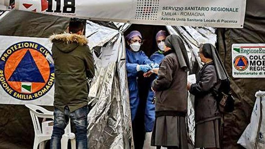 Dues metgesses entreguen medicaments a dues monges al nord d&#039;Itàlia. Dos turistes amb mascaretes a prop del Palau Reial de Madrid.