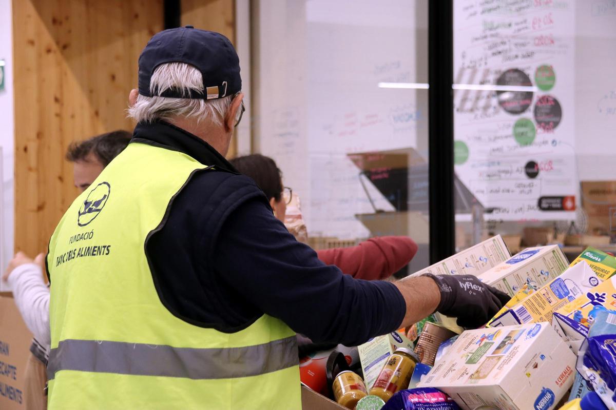 Un voluntario del Banc dels Aliments recoge productos donados para los afectados por la DANA de Valencia