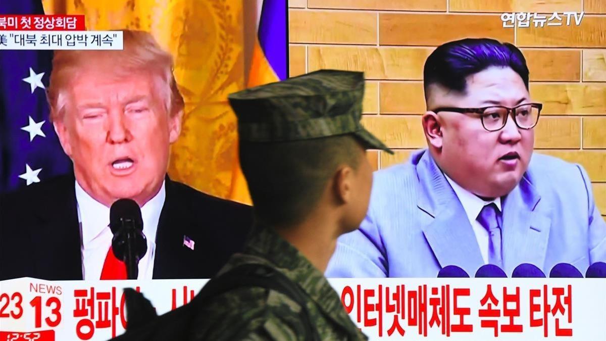 Un soldado surcoreano pasa ante un televisor que muestra las imágenes de Trump y Kim Jong-Un, en Seúl.