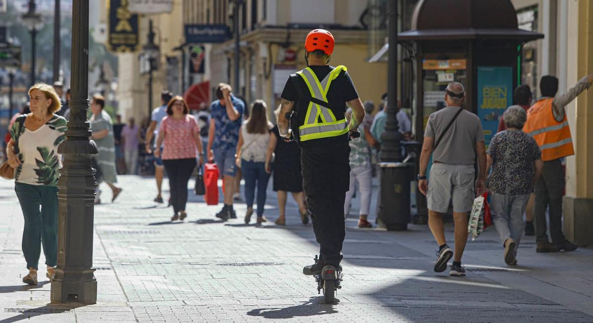 Agentes de la Policía Local , con el conductor de un patinete eléctrico.