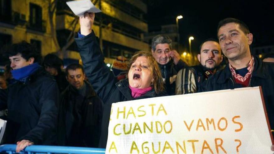 Dos imágenes de la protesta registrada anoche frente a la sede del PP en la madrileña calle Génova.