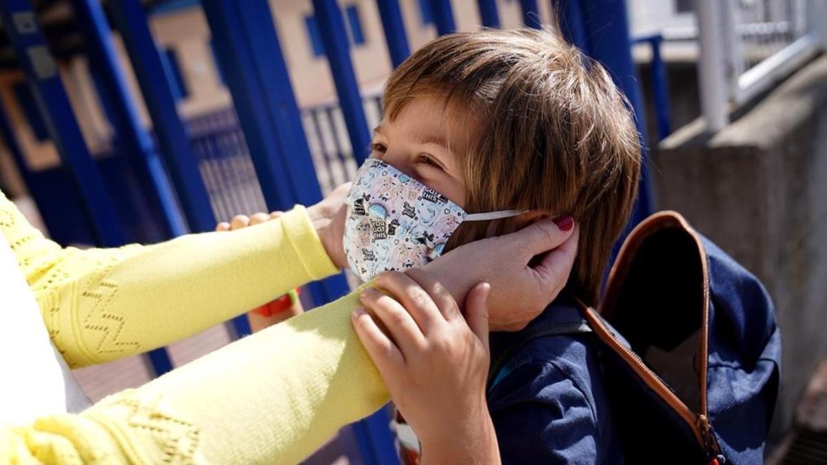 Un niño, protegido con mascarilla, a las puertas de un colegio en Moralzarzal (Madrid).