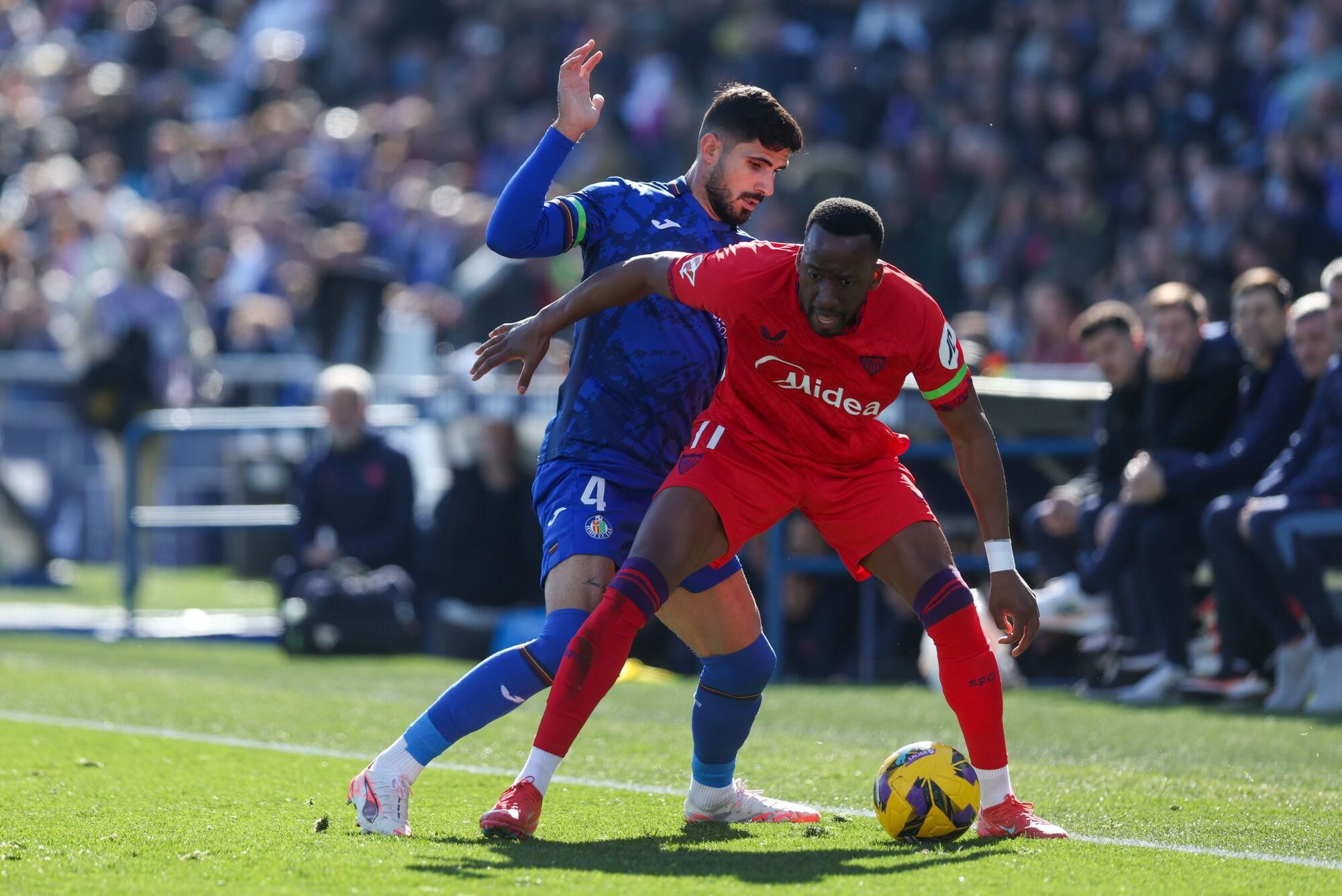 GETAFE (MADRID), 01/02/2025.- El delantero del Sevilla Dodi Lukébakio (d) lucha por el balón con el defensa Juan Berrocal (i) del Getafe durante el partido de LaLiga que enfrenta al Getafe contra el Sevilla este sábado en el Coliseum en Getafe. EFE/ Kiko Huesca