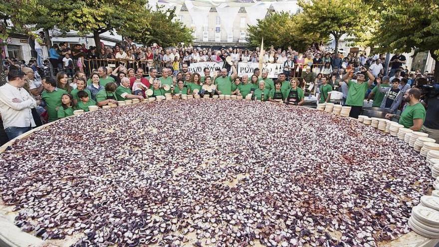 Los pulpeiros de Arcos posan junto a la tapa de cefalópodo más grande del mundo, tras haberla elaborado en la Praza Maior de O Carballiño. // Brais Lorenzo