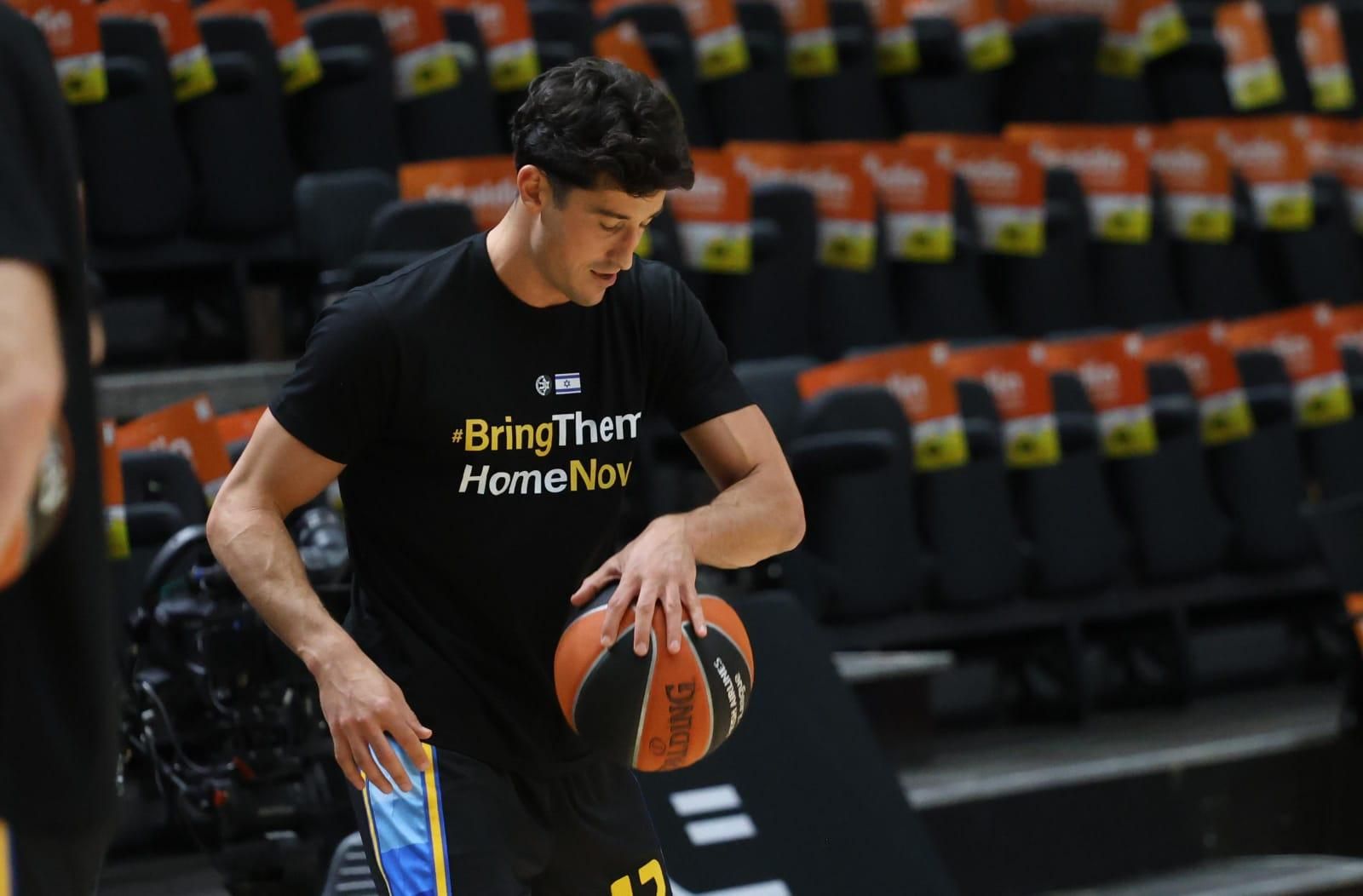 Calentamiento del Maccabi con un mensaje en la camiseta "Bring them home now"
