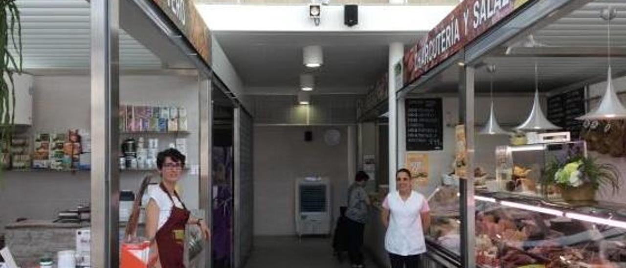 Verónica y Vanesa, frente a sus paradas en el Mercado de Paiporta, con un aparato de aire, al fondo.