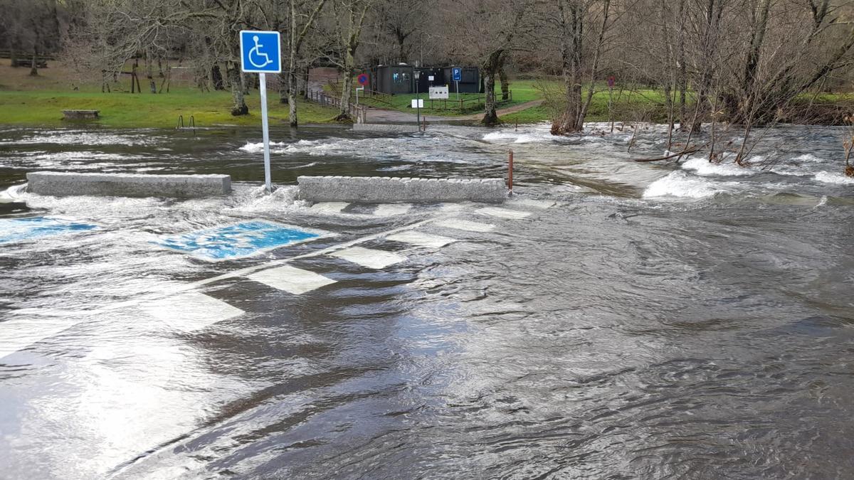 El agua cubre el puente de la playa fluvial de Pozo do Boi 