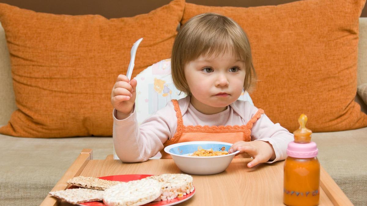 Una niña comiendo sola.