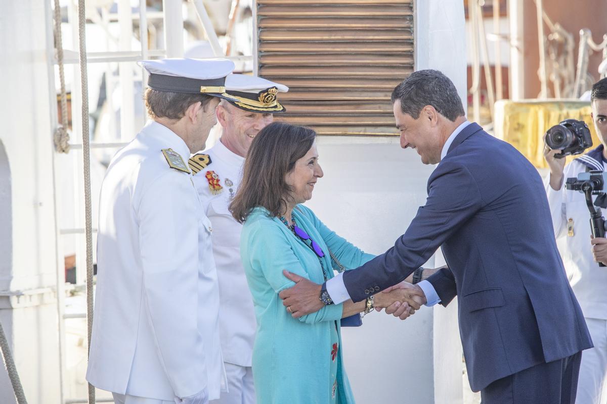 GRAFAND2806. ROTA (CÁDIZ), 06/09/2022.- La ministra de Defensa, Margarita Robles, y el presidente andaluz, Juanma Moreno, se saludan antes de la llegada del rey Felipe VI a bordo del buque escuela de la Armada Juan Sebastián Elcano en la Base Naval de Rota al inicio hoy martes de los actos de conmemoración en aguas de Sanlúcar de Barrameda (Cádiz) de una revista naval para conmemorar que hace hoy 500 años regresó a este mismo lugar, tras un viaje de tres años, la nao Victoria, que, comandada por Juan Sebastián Elcano, fue el primer barco de la historia que dio la vuelta al mundo. EFE/ Román Ríos/ Pool