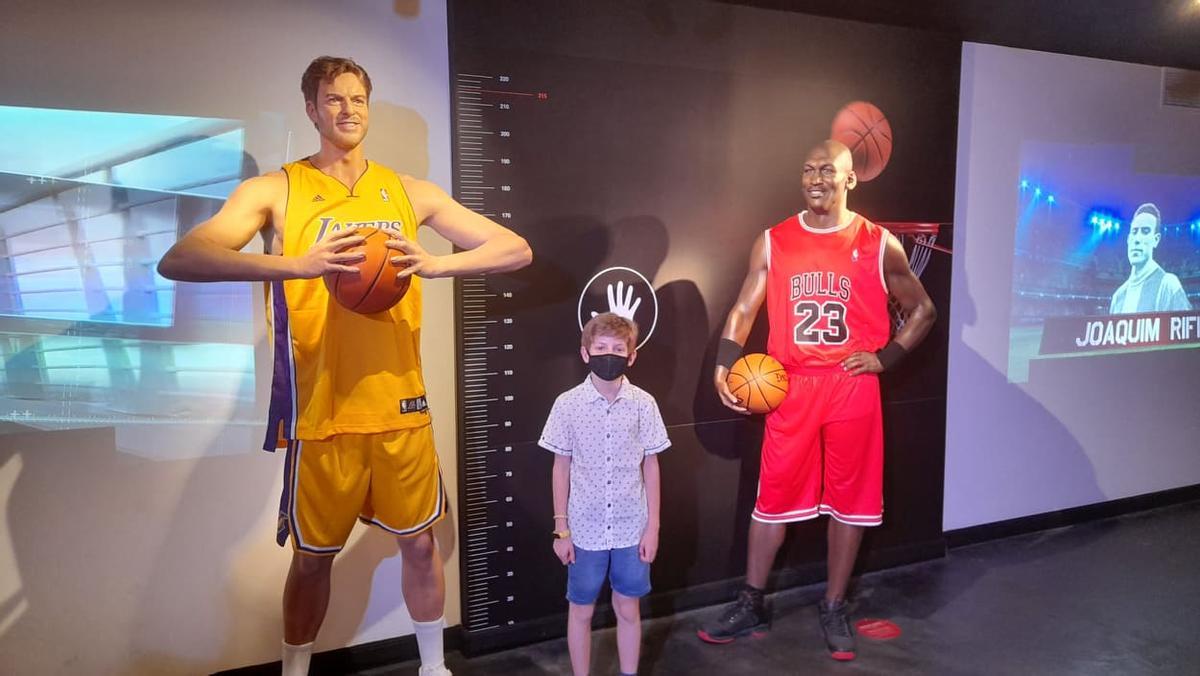 Un niño posa entre los jugadores de baloncesto Pau Gasol y Michael Jordan.