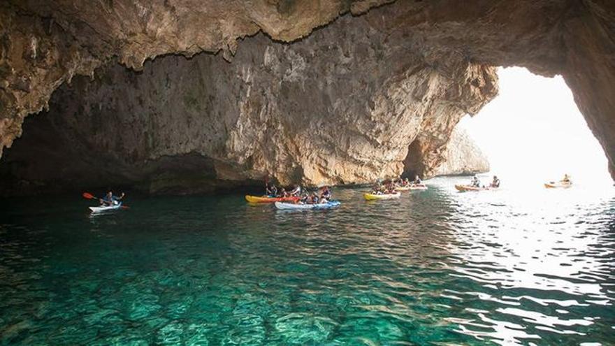 Una excursión de turistas en kayak entra en la Cova dels Òrguens