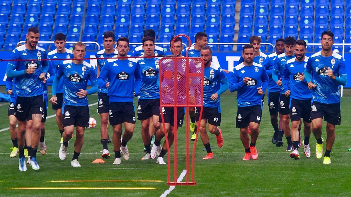 Los futbolistas del Deportivo realizan carrera continua sobre el césped de Riazor. |  // CARLOS PARDELLAS