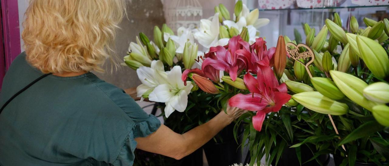 Una vendedora arregla un centro de flores en una tienda de Venegas . | |