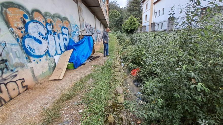 Lo vecinos piden el desalojo de un indigente que durante años ha llenado de basura el arroyo Duró en Mieres