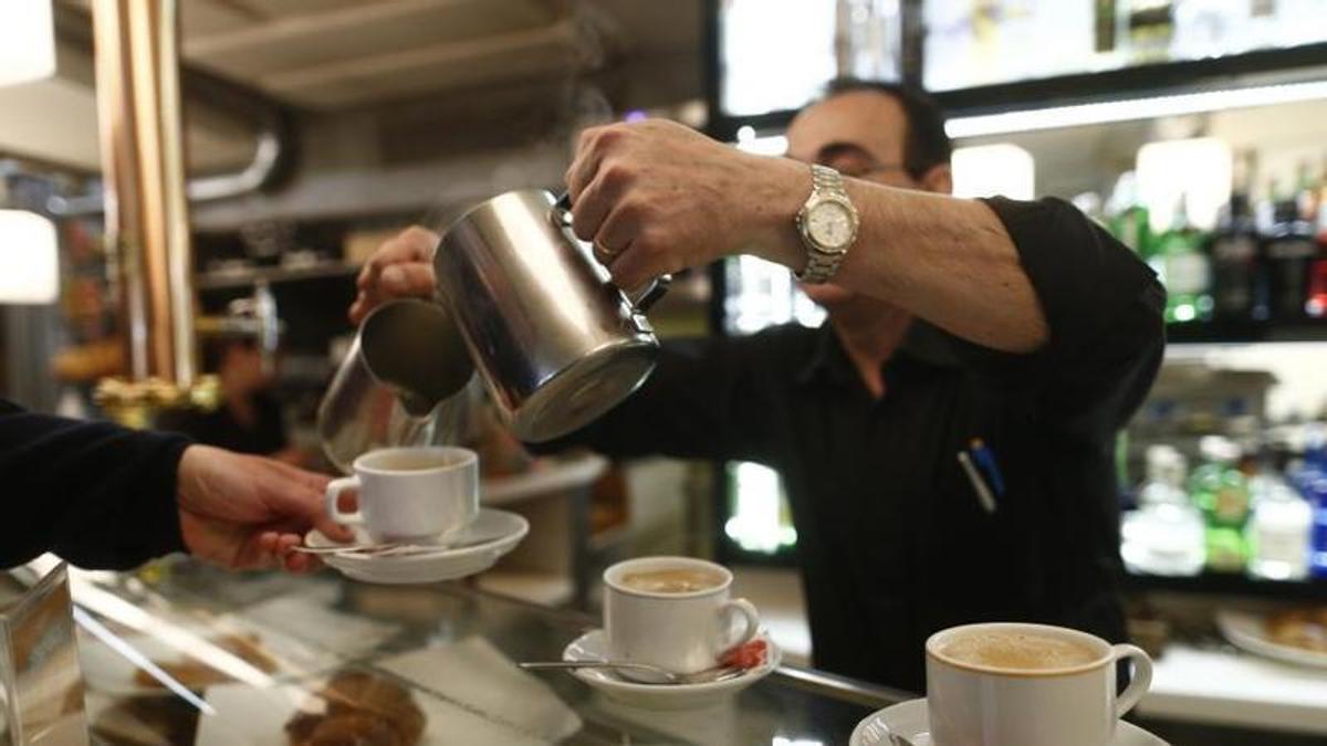 Un camarero sirve un café en un bar. La hostelería es uno de los sectores que concentran mayor pluriempleo.