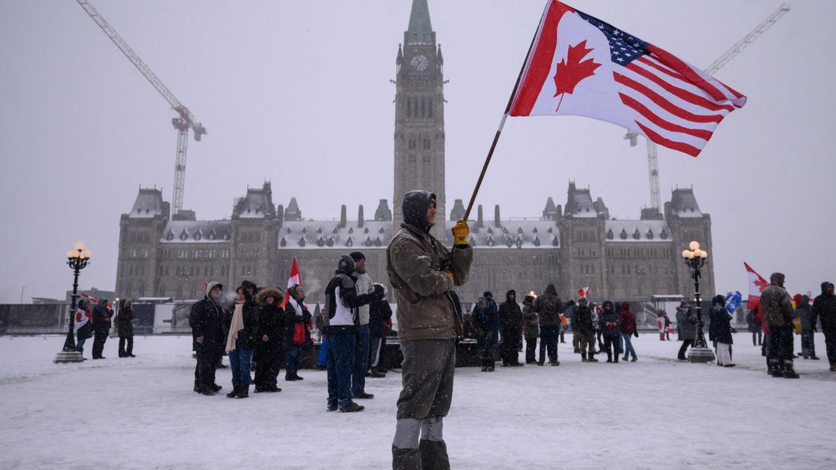 Un manifestantes sostiene una bandera de Estados Unidos y Canadá, durante la protesta en Ottawa