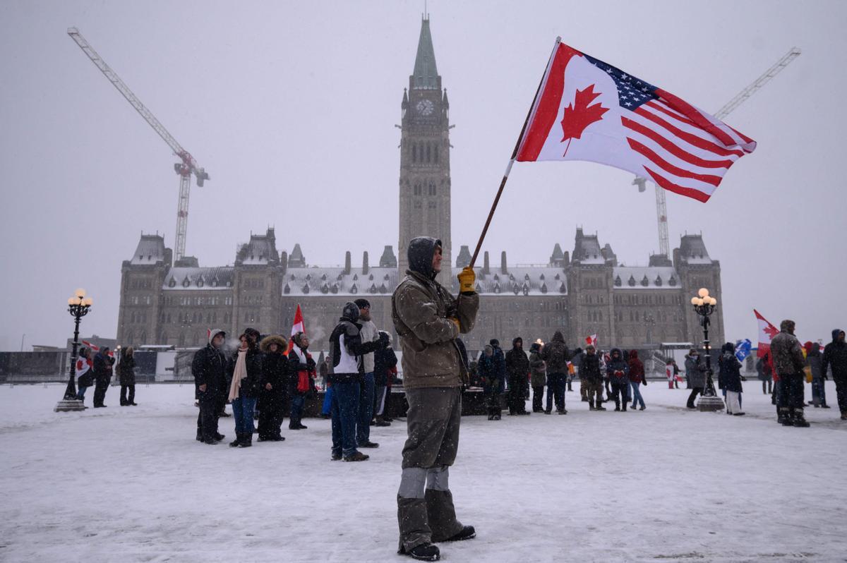 Un manifestantes sostiene una bandera de Estados Unidos y Canadá, durante la protesta en Ottawa.