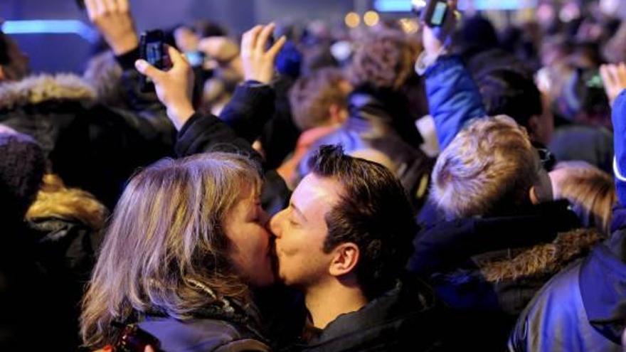 Una pareja se besa en una fiesta de Nochevieja.