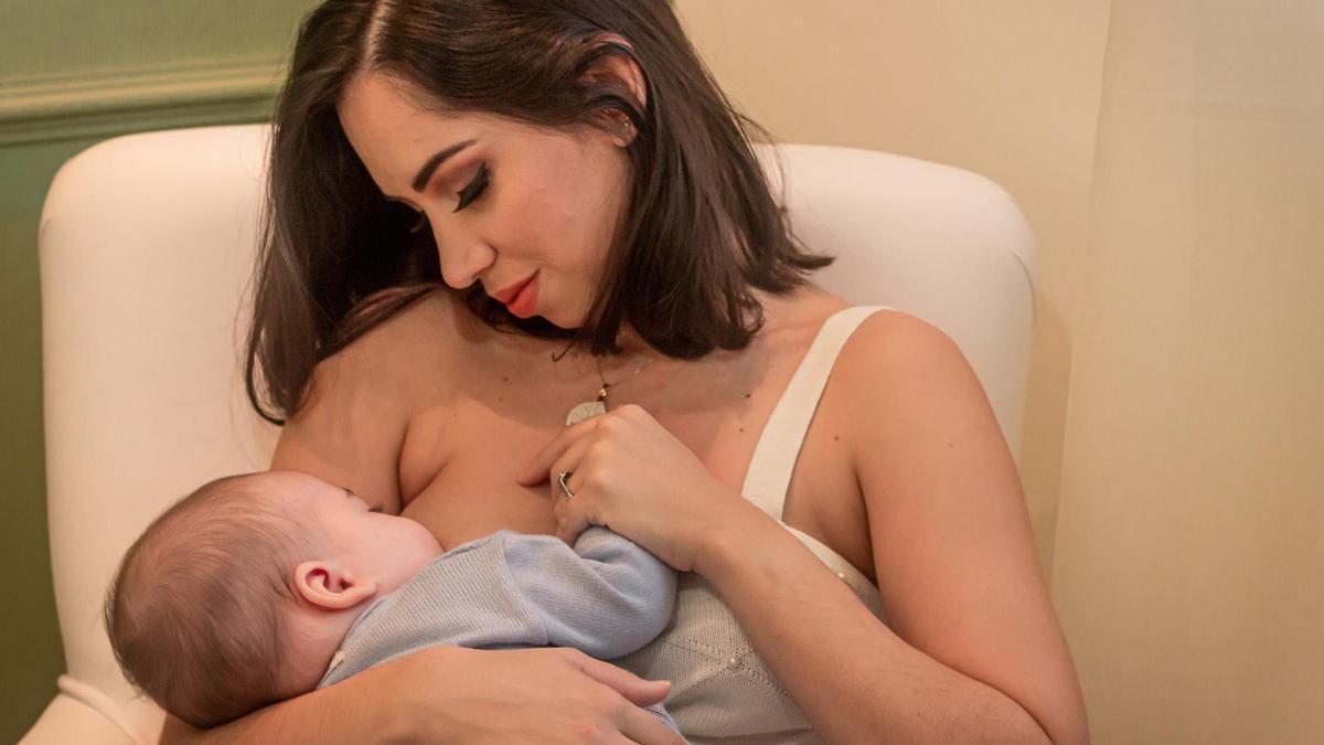 Una mujer dando de mamar a su hijo