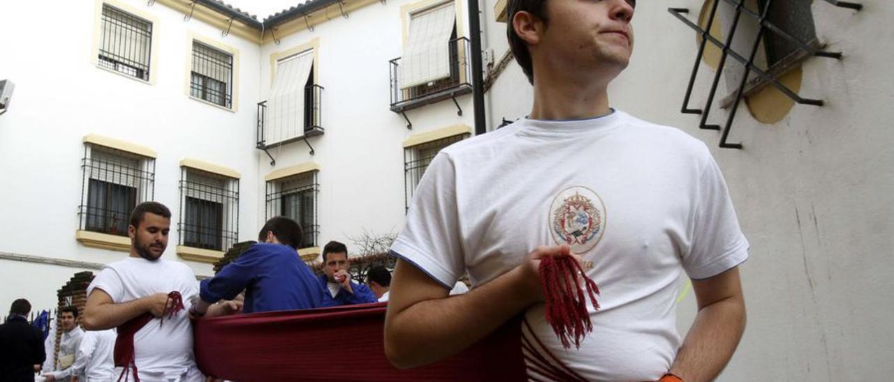 Un grupo de costaleros fajándose antes de la procesión.