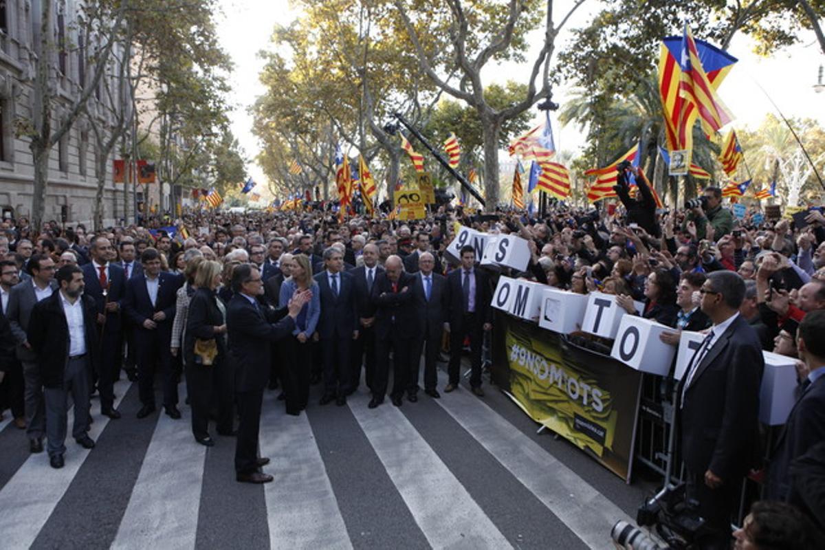 Mas, davant la porta del Palau de Justícia, aplaudeix els ciutadans congregats per donar-li suport.