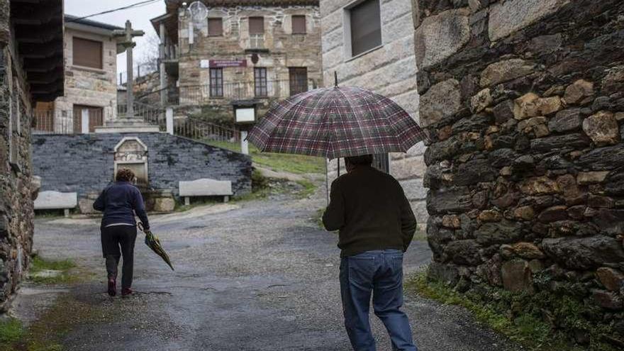 Dos vecinos caminan por una localidad de la comarca sanabresa.