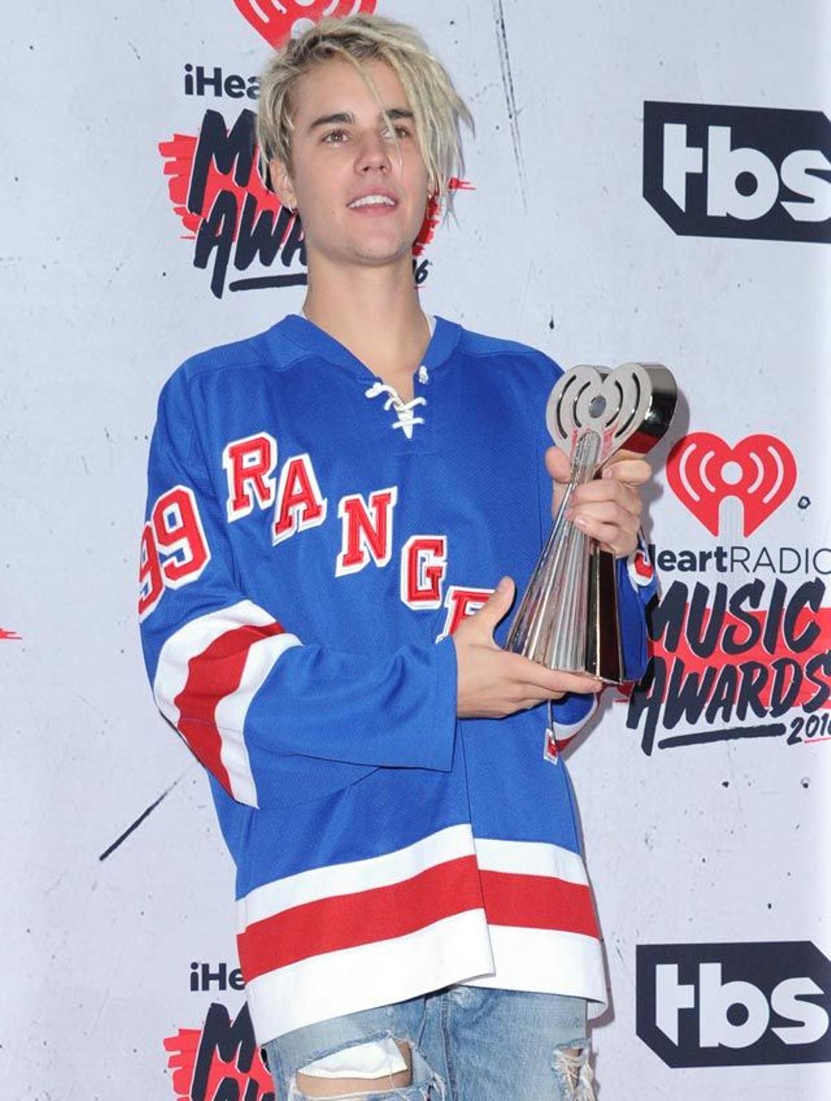 Justin Bieber posa con dos de sus premios tras la gala iHeartRadio Awards 2016.