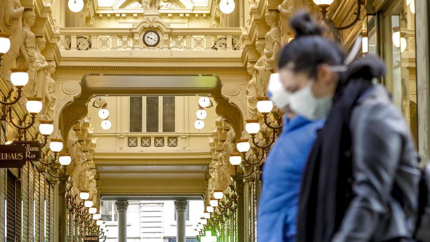 Una mujer pasea con una mascarilla en Bruselas.