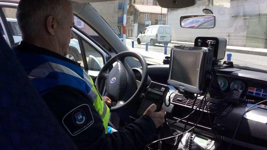 Un agente de la Policía Local de Bueu preparando el radar del vehículo de la DGT. // Santos Álvarez