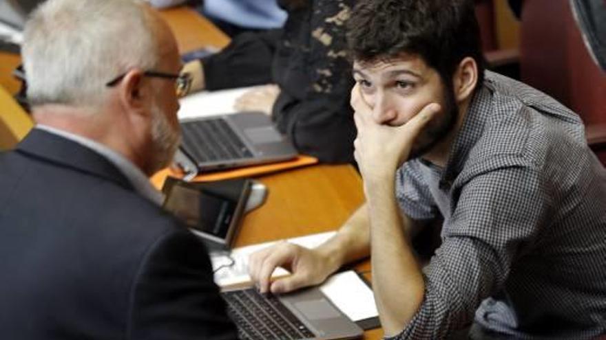 El síndic de Podemos, Antonio Estañ, ayer en las Cortes hablando con su antecesor en el cargo, Antonio Montiel.