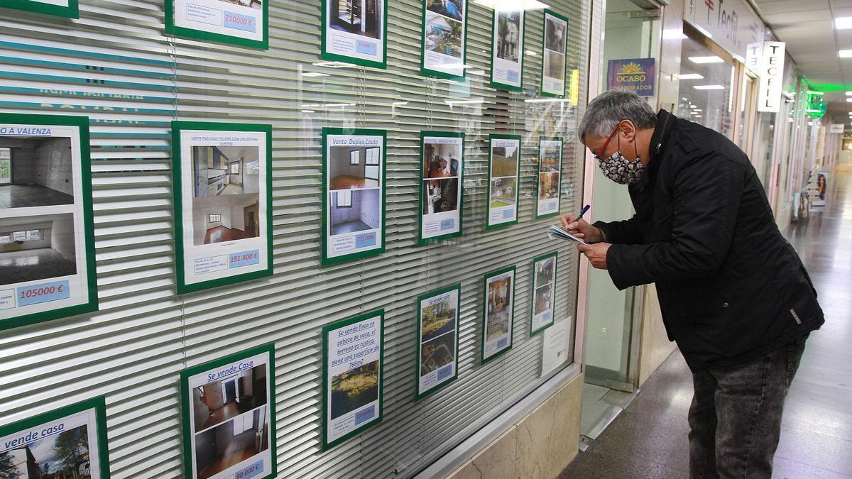 Un hombre toma nota de viviendas en alquiler y en venta en una inmobiliaria de Ourense