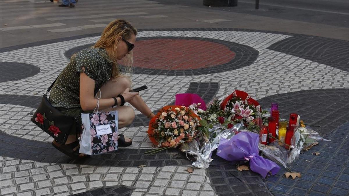 Una mujer deposita flores en La Rambla, en la víspera del primer aniversario del atentado del 17A