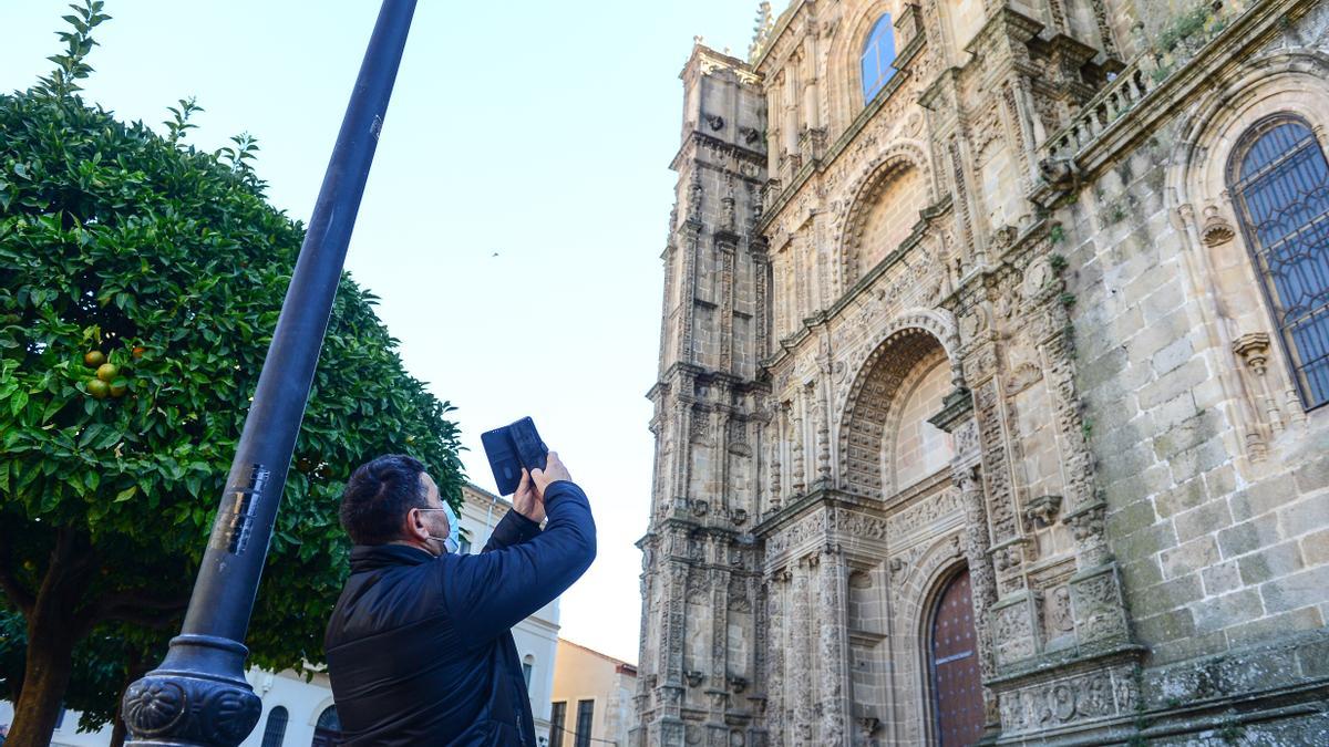 Un turista, echándole una foto a la catedral de Plasencia.