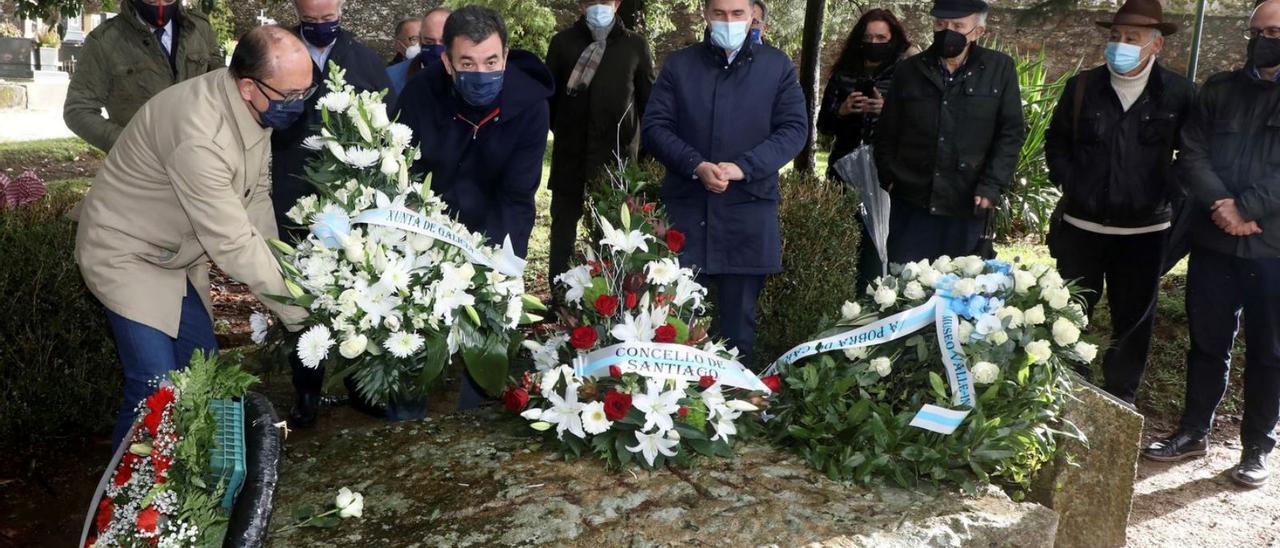 El conselleiro Román Rodríguez depositando una de las coronas sobre la tumba del escritor. |