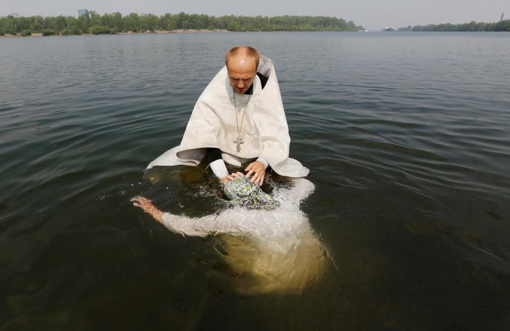 Un sacerdote ortodoxo bautiza a una mujer en el río Yenisei durante una ceremonia que marca la cristianización del país.
