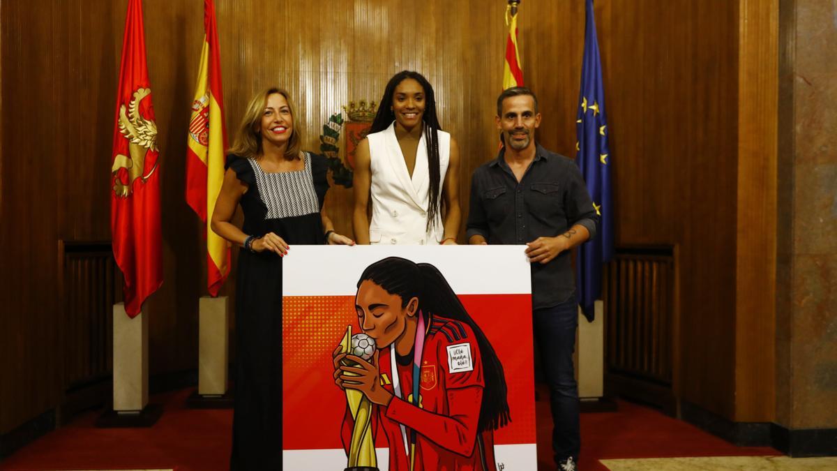 Salma Paralluelo posa junto a la alcaldesa de Zaragoza, Natalia Chueca, y el ilustrador José Antonio Bernal.