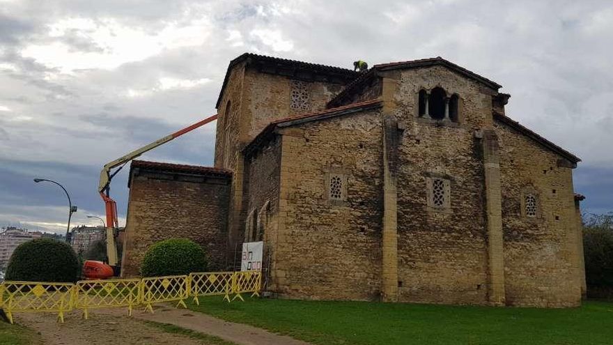 Un operario, ayer, sobre el tejado de la iglesia de San Julián de los Prados, realizando labores de limpieza.