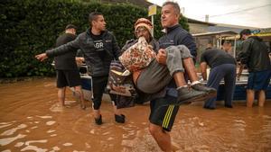 Una mujer es evacuada de una zona inundada de Porto Alegre.