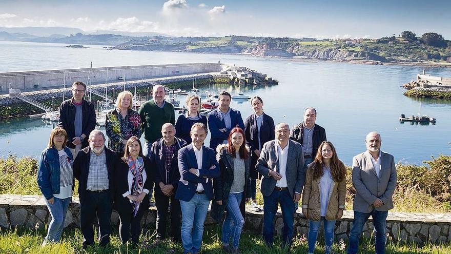 Foto de familia de la candidatura del PSOE de Gozón tomada desde La Mofosa, con vistas al puerto luanquín.